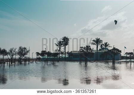 Beach Cafe And Palm Trees In Water With Reflection After Storm That Caused Flooding. Natural Disaste