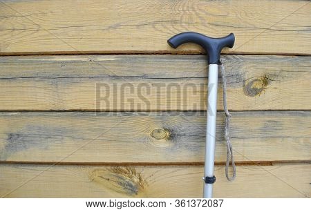 Close-up Of A Walking Stick On A Wooden Background.