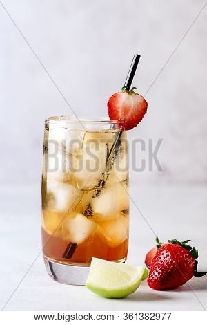 Glasses Of Cold Citrus And Strawberry Ice Tea On Light Gray Background Decorated With Ripe Lime And 