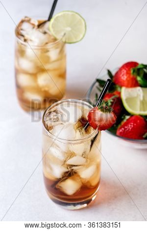 Glasses Of Cold Citrus And Strawberry Ice Tea On Light Gray Background Decorated With Ripe Lime And 