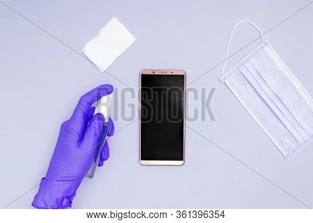 Hands Wearing Protective Gloves Cleaning And Desinfecting Mobile Phone For Covid-19 Coronavirus Dise