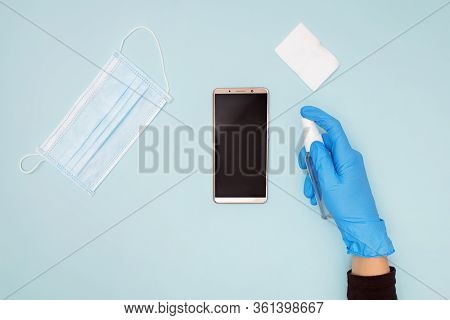Hands Wearing Protective Gloves Cleaning And Desinfecting Mobile Phone For Covid-19 Coronavirus Dise