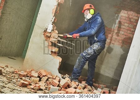 demolition work and rearrangement. worker with sledgehammer destroying wall
