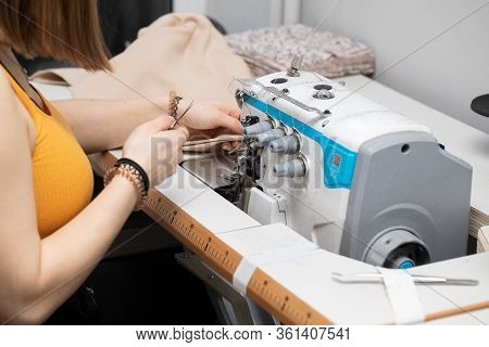 A Young Girl Learns To Sew On A Specialized Sewing Machine.