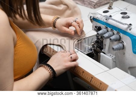 A Young Girl Learns To Sew On A Specialized Sewing Machine.