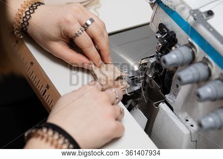 A Young Girl Learns To Sew On A Specialized Sewing Machine.