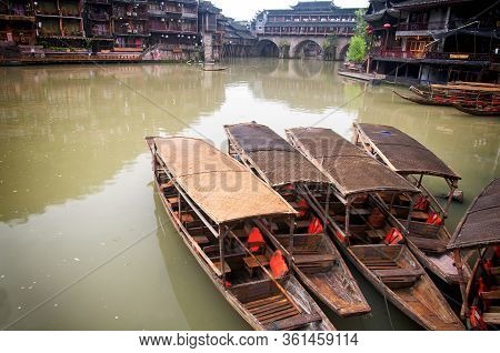Weathered Wooden Tourist Boats Docked On The Edge Of The Tuojiang River In Fenghuang Village Morning