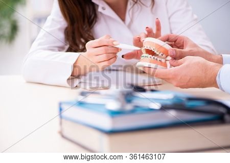 Young male doctor stomatologist and female student in the classr