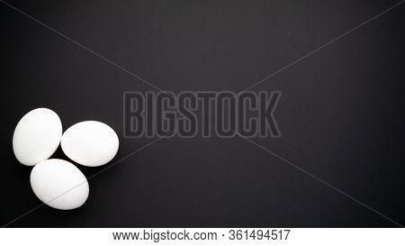 Composition Of Three Chicken Eggs With White Shell Of Boiled Or Raw. White And Black Contrast In Egg
