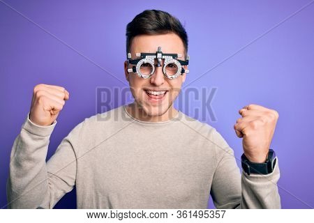 Young handsome caucasian man wearing optometrical glasses over purple background celebrating surprised and amazed for success with arms raised and open eyes. Winner concept.