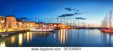 Night View Of The Alghero Marina Yacht Port At The Gulf Of Alghero With Anchored Sailboats. Location