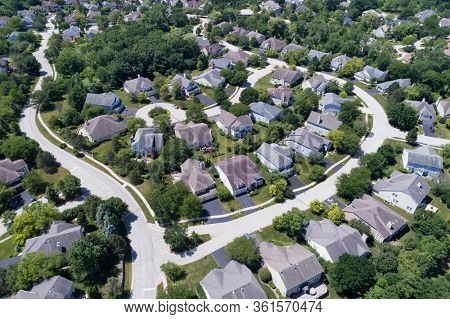 Aerial view of a tree-lined, suburban neighborhood with cul-de-sac in summer.