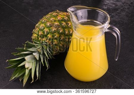 Carafe With Fresh Pineapple Juice On A Black Background.
Close-up.