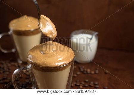 Cold Dalgona Coffee In Clear Glasses On A Dark Wooden Background. Froth Of Sugar And Instant Coffee