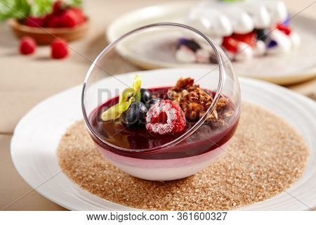 Berry Panna Cotta with Currant-Cointreau jelly in glass bowl. Creamy dessert with berries close up. Sweet meal, raspberry and blackcurrant souffle. Served gourmet appetizer, delicious restaurant food