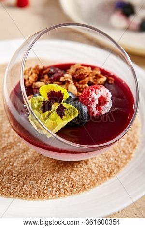 Berry Panna Cotta with Currant-Cointreau jelly in glass bowl. Creamy dessert with berries close up. Sweet meal, raspberry and blackcurrant souffle. Served gourmet appetizer, delicious restaurant food