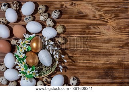 Easter Eggs In Basket Filled With Straw And Yellow Flowers And Willow On Wooden Rustic Vintage Backg