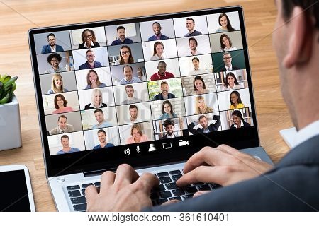 Man Working From Home Having Online Group Videoconference On Laptop