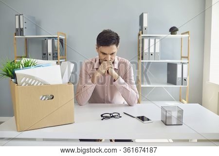Unemployment. Dismissal. Dismissed Businessman Is Upset With A Cardboard Box Holding His Head In His