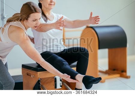 Older Women Doing Pushups. Young Personal Trainer Helping Senior Woman. Workout In Rehabilitation Ce