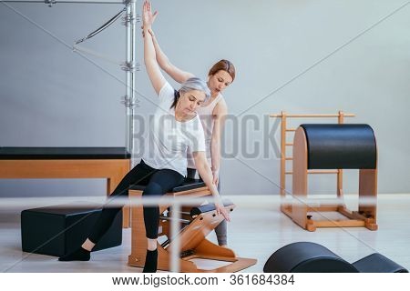 Older Women Doing Pushups. Young Personal Trainer Helping Senior Woman. Workout In Rehabilitation Ce