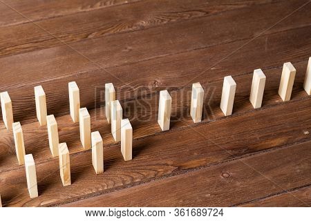 Rows Of Dominoes Standing On Wooden Table. Business Assistance And Management Concept With Wooden Bl