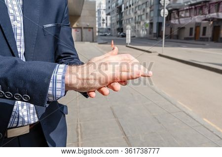 Businessman In A Blue Suit Using Small Portable Antibacterial Sanitizer Applying Antiseptic For Wash