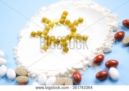 Vitamin D Yellow Pills In The Shape Of Sun On White Lecitin Powder In Sky Blue Background, Nutrition