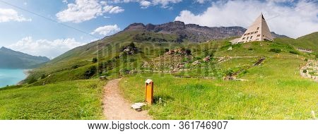 Lake And Meadow By The Mountains In The French Alps