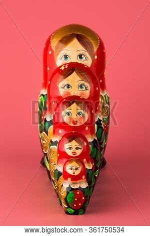 Russian Folk Wooden Doll On A Pink Background
