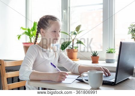Schoolgirl Looks At A Laptop Screen. Social Distance, Self- Isolation. Home School, Online Education