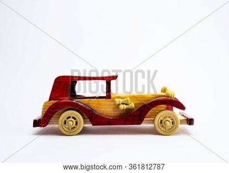 Side Profile Shot Of A Vintage Toy Car Made With Wood, Shot Against White Background For Royalty Con