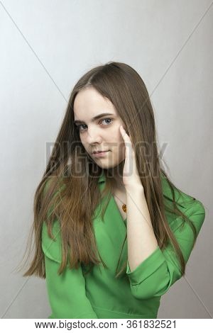 Young Romantic Girl With Long Blond Hair In A Green Dress Is Sad In Melancholy. Profile Girl.