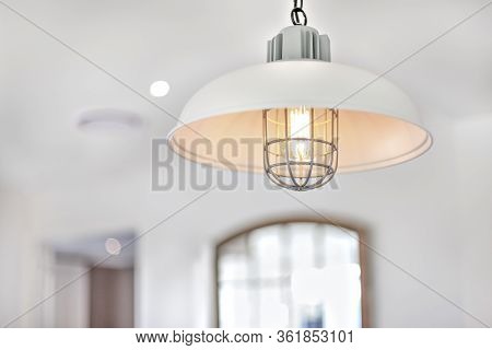 Hanging Spot Lamp Flashing With A Blurred Background In A Modern House, There Is A Metal Cable Cover
