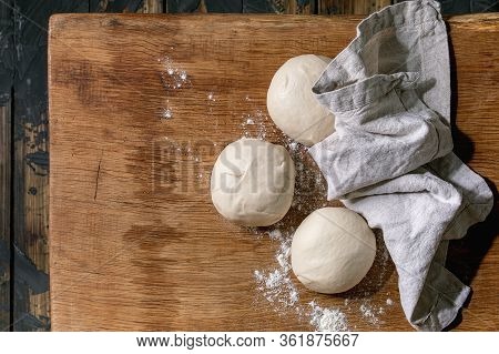 Dough For Pizza Cooking. Three Balls Of Fresh Homemade Wheat Dough Under Linen Cloth On Wooden Table