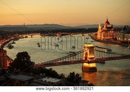 Night View Of The City Of Budapest On The Danube River On Which Ships With Illuminated Bridge And Pa