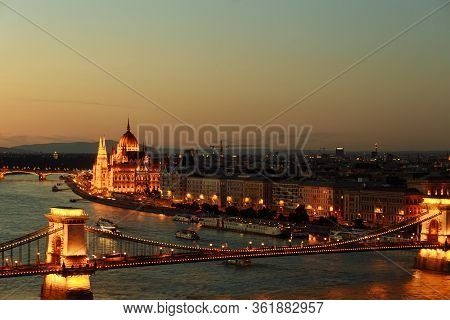 Night View Of The City Of Budapest On The Danube River On Which Ships With Illuminated Bridge And Pa