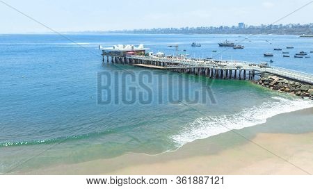 Private beach club in the district of Chorillos with distant shore covered in air pollution haze in 