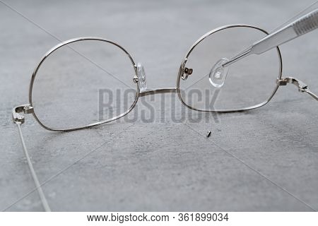 Closeup Of Professional Repairing Of Eyeglasses With Ophthalmology Instrument In Clinic Office And O