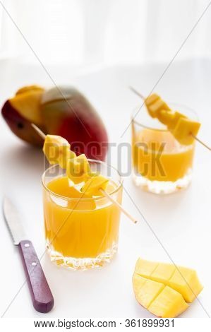 Fresh Mango Juice. Sliced Mango And Knife. Slices Of Mango On A Glass With Juice.