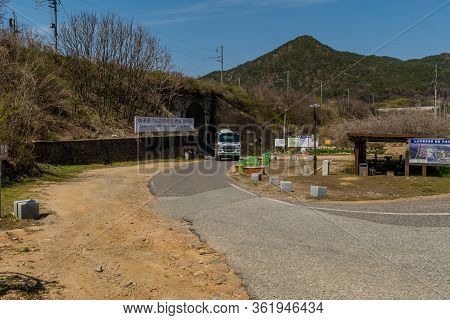 Hwanggan, South Korea; April 14, 2020: Cement Mixer Driving On One Lane Road In Front Of Tunnel At L