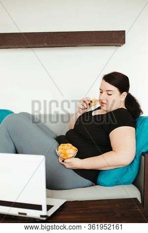 Overeating And Gluttony Concept. Mindless Snacking, Home Sedentary Lifestyle. Obese Woman Sitting On