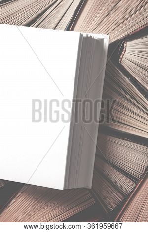 Mockup Of Closed Blank Square Book Rests On Open Old Multicolored Books