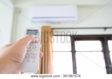 Concept Of Save Power Energy Save Sustainability World. Hand Push Down Button Air Conditioner Remote
