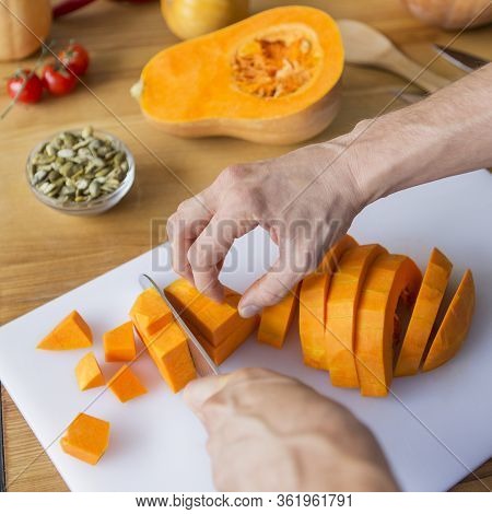 Man Cutting Fresh Pumpkin On Slices For Making Soup, Tasty Vegetarian Meal, Boosting Immunity