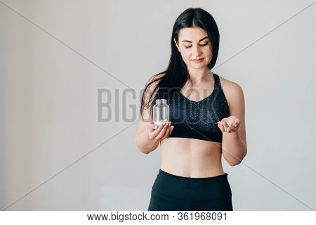 Sport, Diet Supplements And Fitness Nutrition. Fit Woman Taking Pills, Copy Space. Pharmacy