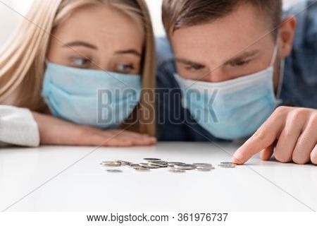 Coronacrisis Concept. Young Couple Counting Las Money Savings At Home, Close Up
