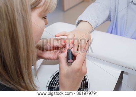 Nail Care - Applying A Base Coat. The Master Applies A Transparent Base Coat To The Clients Nails.