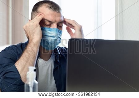 Coronavirus And Coronacrisis. Stressed Man At Laptop Massaging Temples Having Business Problems Sitt