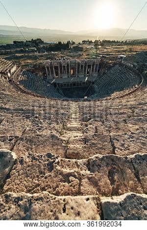 Ruins Of Ancient Hierapolis Amphi Theatre With Tourist Pamukkale, Denizili, Turkey. Evening Sun